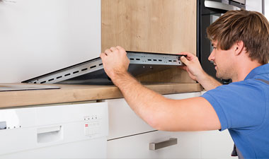 Man installing kitchen appliance