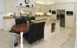 Kitchen and dining area with cream drawers/cupboards and marble bench