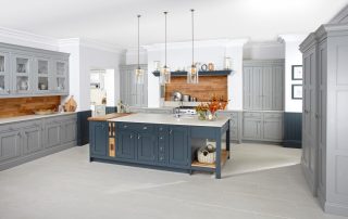 Modern kitchen with central bench with built in blue drawers and cupboards