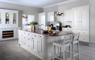 Modern kitchen with white cupboards and drawers, some built into the bench