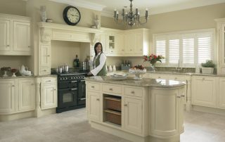 Woman in kitchen with white cupboards and drawers
